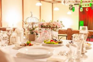 a table with plates of food and flowers on it at Alean Family Resort & SPA Riviera 4* Ultra All Inclusive in Anapa
