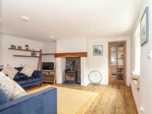 uma sala de estar com um sofá azul e uma lareira em Swallows Nest em Penzance
