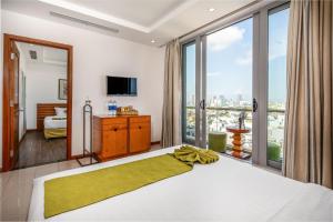 a bedroom with a large bed with a large window at Richico Apartments And Hotel in Da Nang
