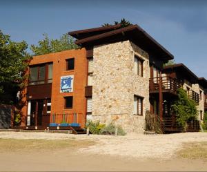 Un edificio de ladrillo con un cartel delante. en Cabañas Mar de Luna, en Villa Gesell