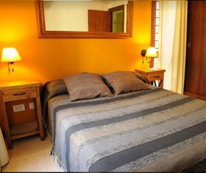 Un dormitorio con una cama con dos mesitas de noche y dos lámparas. en Cabañas Mar de Luna, en Villa Gesell 19 fotos más