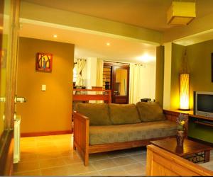 Una sala de estar con un sofá y un televisor. en Cabañas Mar de Luna, en Villa Gesell