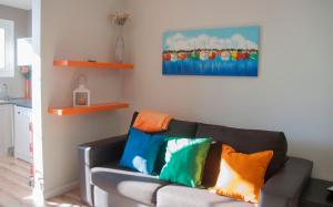 sala de estar con sofá y almohadas coloridas en Feel at Sants Apartments, en Barcelona