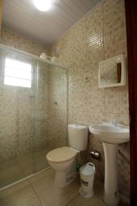 a bathroom with a toilet and a sink at Casas em Ubatuba in Ubatuba