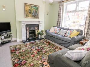 a living room with a couch and a fireplace at West View Cottage in Settle