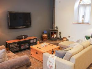 a living room with a couch and a fire place at Bausley Chapel in Melverley