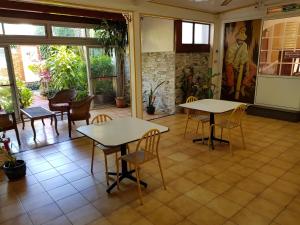 due tavoli e sedie in una stanza con finestre di Hotel CHEZ PAPA DAYA a Saint-Pierre