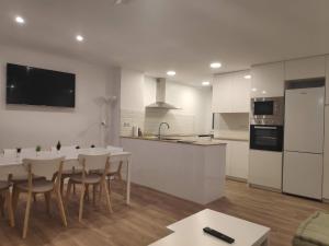 a white kitchen with a table and chairs and a counter at SUITEDREAMS - Pollancre 23 in Andorra la Vella