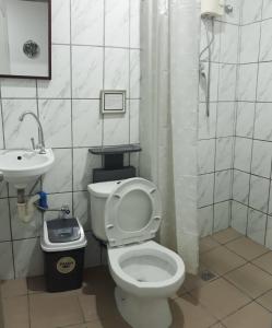 a bathroom with a toilet and a sink at Hotel Sisters Inn in Moalboal