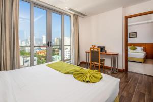 a bedroom with a white bed with a large window at Richico Apartments And Hotel in Da Nang