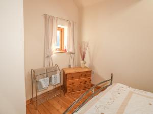 een slaapkamer met een bed, een dressoir en een raam bij Swallows Nest in Launceston