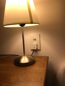 a lamp sitting on a table next to a light switch at Hotel Luanco in Temuco