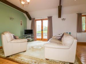 ein Wohnzimmer mit 2 weißen Sofas und einem TV in der Unterkunft Swallows Nest in Launceston