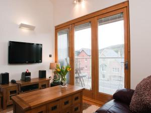 een woonkamer met een flatscreen-tv en een bank bij Quay Lodge in Dartmouth