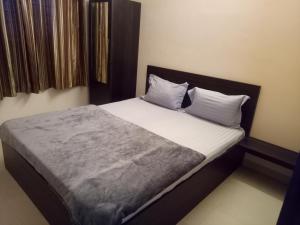 - un lit avec des draps et des oreillers blancs dans l'établissement Tranquil Serviced Apartments, à Bangalore