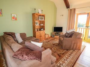 a living room with a couch and two chairs at Barn Owl Cottage in Launceston