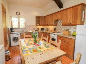 eine Küche mit einem Holztisch mit einer Tischdecke darauf in der Unterkunft Barn Owl Cottage in Launceston