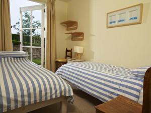 two beds sitting next to each other in a bedroom at 3 Combehaven in Salcombe