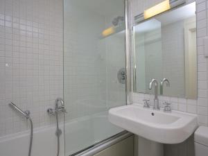 a white bathroom with a sink and a shower at 3 Combehaven in Salcombe