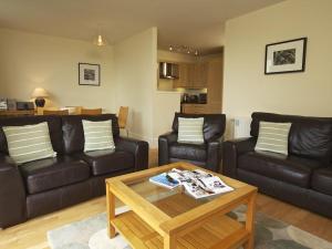 a living room with leather couches and a coffee table at 3 Combehaven in Salcombe