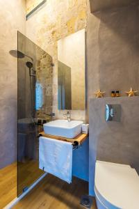 a bathroom with a sink and a toilet and a mirror at Aelios Design Hotel in Chania Town