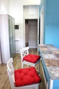 Zimmer mit 2 Stühlen und einem Tisch mit roten Stühlen in der Unterkunft Funky flat in Palermo
