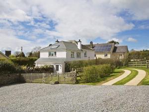 a white house with a fence and a driveway at Cloverwell in Kingsbridge