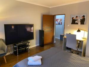a room with a bed and a flat screen tv at DK Apartament Reymonta in Olsztyn