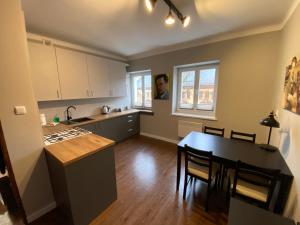 a kitchen and dining room with a table and chairs at DK Apartament Reymonta in Olsztyn
