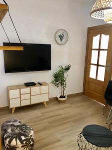 uma sala de estar com uma televisão de ecrã plano na parede em Vilamarlux IV em Vilassar de Mar