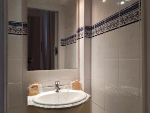 uma casa de banho branca com um lavatório e um espelho em Villa Eden em Nice