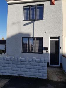 Casa blanca con ventana y pared de ladrillo en Swindon Theobald House - EnterCloud9SA, en Swindon