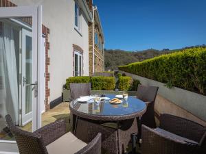 a patio with a table and chairs on a balcony at 4 Dart Marina in Dartmouth