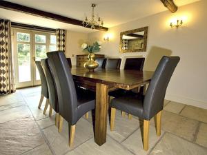 a dining room with a wooden table and black chairs at Goldcrest in Meerbrook