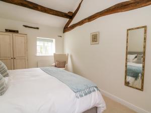 - une chambre avec un lit et un miroir dans l'établissement Croft Cottage, à Skipton