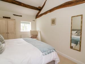 a bedroom with a bed and a mirror at Croft Cottage in Skipton
