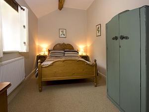 a bedroom with a bed with two lamps and a window at Honeystone in Leek
