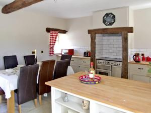 a kitchen with a table and chairs and a stove at Honeystone in Leek