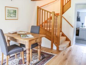 a dining room with a table and chairs and a staircase at Croft Cottage in Skipton