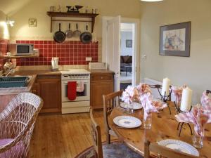 uma cozinha com uma mesa de madeira e uma sala de jantar em Bank View em Duns