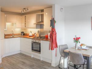 a kitchen with white cabinets and a table with a red towel at All Aboard in Whitby