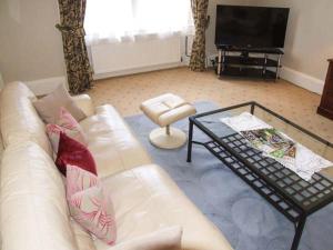 uma sala de estar com um sofá branco e uma mesa de centro em Bank View em Duns