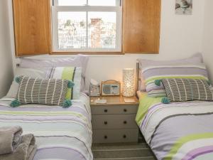 um quarto com 2 camas e uma mesa com rádio em All Aboard em Whitby