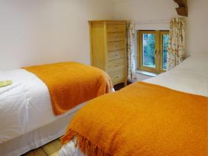 a bedroom with two beds and a window at The Woodshed in Upton Pyne