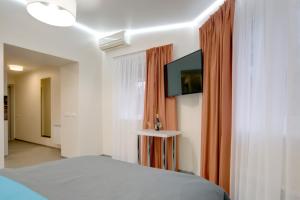 a bedroom with a bed and a flat screen tv at Arena Summit Apart Hotel in Kyiv