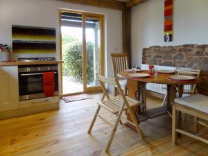uma cozinha com uma mesa de madeira, uma mesa e cadeiras em The Woodshed em Upton Pyne