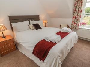 a bedroom with a large white bed with towels on it at 31 Peth Head in Wooler