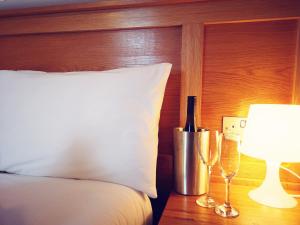 a bedroom with a bed with a bottle of wine and a lamp at The Bank House in Bundoran