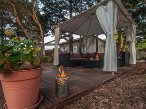 eine Terrasse mit einem Sonnenschirm und einer Kerze auf einer Holzterrasse in der Unterkunft Silba Otium in Silba