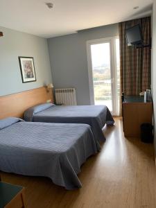 pokój hotelowy z dwoma łóżkami i telewizorem w obiekcie Hotel Área de Calahorra w mieście Calahorra